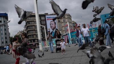 People walk in front of the poster of Turkish President Recep Tayyip Erdogan which reads, 'Thank you Istanbul' at Taksim Square in Istanbul, Turkey, 26 June 2018. Turkish Electoral Commission on 26 June announced Mr Erdogan had won the presidential elections. Sedat Suna / EPA