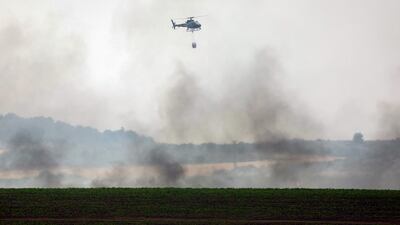A helicopter prepares to drop water on a forest fire in central Israel. AFP