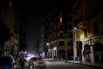 A Cairo street in darkness after shops closed early during the curfew. AFP