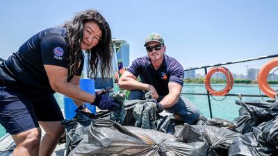 Dive volunteers with the collected bags of trash at Abu Dhabi Dhow Harbour. Victor Besa / The National