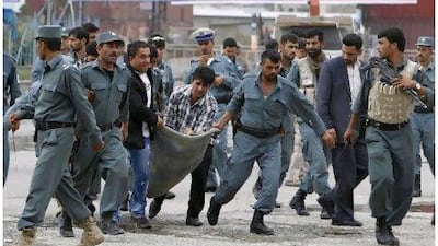Afghan policemen carry a policeman who is a casualty of the Taliban attack on the heart of Kabul's diplomatic and military enclave. Omar Sobhani / Reuters
