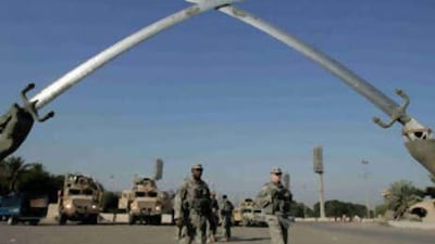 US Army soldiers walk under the "crossed swords" monument in the US-protected Green Zone in Baghdad.