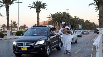 A Libyan man distributes snacks and water to motorists to breaking their fast in Tripol. AFP