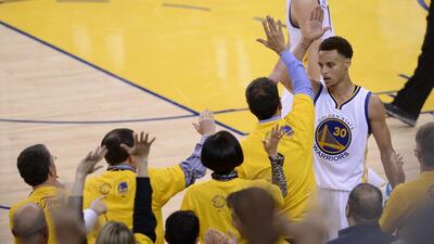 Golden State Warriors guard Stephen Curry (R) high-five fans after scoring against the Cleveland Cavaliers in the second half of Game Five of the NBA Finals at Oracle Arena in Oakland, California, USA, 14 June 2015. The winner of best of seven series will be NBA Finals Champions. EPA/JOHN G. MABANGLO CORBIS OUT