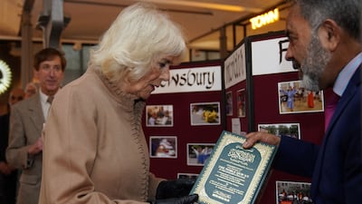 Queen Camilla receives a copy of the Quran from John Mustafa during a visit to Shrewsbury in England. AFP