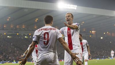 Poland's Robert Lewandowski celebrates with teammates after scoring one of his two goals in a 2-2 draw with Scotland on Thursday night in Glasgow. Robert Perry / EPA / October 8, 2015