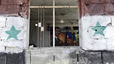 A picture of Syria’s President Bashar Al Assad is seen inside a checkpoint at the site of a car bomb on the outskirts of the Sayeda Zeinab district south of Damascus, Syria. Omar Sanadiki / Reuters
