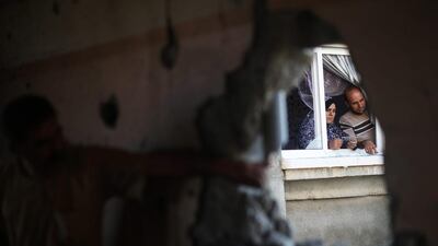Palestinians check the damage in their house after it was hit by Israeli tank fire in Beit Hanun in the northern Gaza Strip. Mohammed Abed / AFP