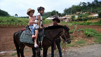 Girls riding a pony on the road leading to the Tham Luang cave. AFP