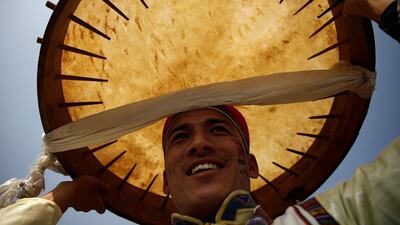 A man dressed in traditional attire holds a drum above his head in Kathmandu, Nepal. Reuters