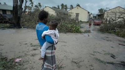 A woman and child near a school building being used as emergency shelter for some 300 local people who are unable to return to their homes following cyclone force winds and heavy rain in the coastal city of Beira, Mozambique. CARE via AP