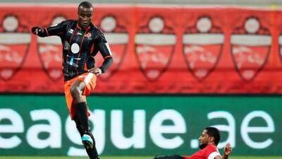 Al Ahli’s Abdulaziz Sanqour, right, tackles Founeke Sy of Ajman in Dubai on Saturday night. Al Ahli’s 3-0 win sealed second place in the league table. Al Ittihad