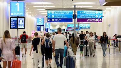 People arrive for their flights at Dubai International Airport. Chris Whiteoak / The National