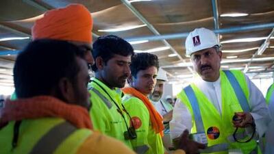 The UAE Minister of Labour Saqr Ghobash Saeed Gobash hands out mobile phones to construction workers at the construction site of the Al Jalila Children's Speciality Hospital.