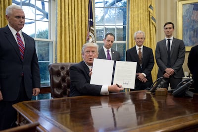 US President Donald Trump holds up an executive order pulling America out of the Trans-Pacific Partnership on January 23, 2017. Bloomberg