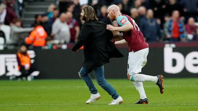 A fan clashes with West Ham United's James Collins after invading the pitch. David Klein / Reuters