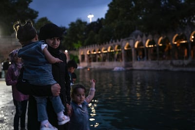 A Syrian family walk near Balikligol lake in Sanliurfa, Turkey, in May last year. AFP