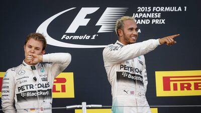 Lewis Hamilton, right, celebrates on the top of the Japanese Grand Prix podium while teammate Nico Rosberg, left, looks on. Diego Azubel / EPA