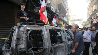 Residents inspect a burnt vehicle at the site of the two explosions that occurred on November 12 in the southern suburbs of the Lebanese capital Beirut. November 13. Reuters