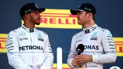 Ferrari driver Kimi Raikkonen, right, of Finland reacts as winner Mercedes F1 driver Nico Rosberg of Germany jumps on the podium during the Russian Grand Prix. REUTERS/Maxim Shemetov