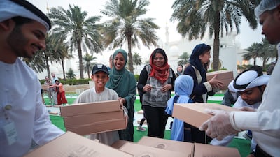 Jusoor volunteers distribute iftar meals at the mosque. Victor Besa / The National
