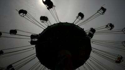 A visitor enjoys the swing ride at the Yomiuriland amusement park in Tokyo. The park has been closed since the end of March due to the new coronavirus, has taken measures to prevent infections and reopened limited attractions. AP Photo