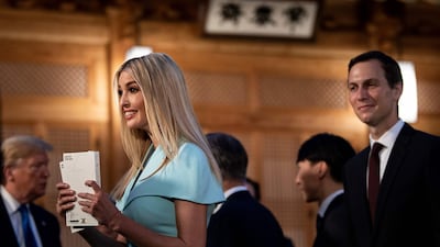 US Senior Advisor Jared Kushner, right, watches as his wife and Advisor to the US President Ivanka Trump, left, holds copies of K-pop band Exo's album 'Love Shot', as US President Donald Trump, background left, waits for a working dinner with South Korea's President Moon Jae-in at the tea house on the grounds of the presidential Blue House in Seoul. AFP