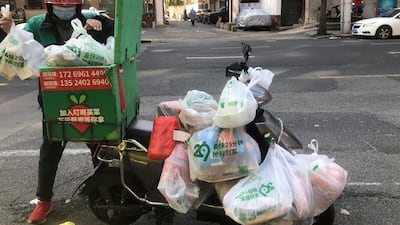 A delivery man arranges his orders during lockdown in the Jingan district of western Shanghai. AP