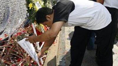 A mourner lays flowers at a makeshift shrine outside the Ritz Carlton Hotel bombing site in Jakarta.