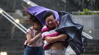 People struggle with the wind as they cross the street under the rain as Typhoon Mitag approaches northern Taiwan, in Keelung. EPA
