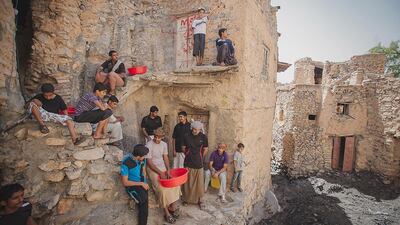 Zaher Sulaiman and his family enjoy the shuwah meat, baked in a special spice marinade, wrapped in banana leaves and cooked for two days. Ania James for The National