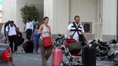 Residents coming out with their belongings after police and Dubai Civil Defense gave them permission to go inside the Tamweel tower in Jumeirah Lakes Towers which caught fire. Pawan Singh / The National