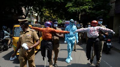Policemen hold effigys of demons representing the Covid-19 Coronavirus during an awareness campaign along a street in Chennai as India surged past 13 million coronavirus cases. AFP
