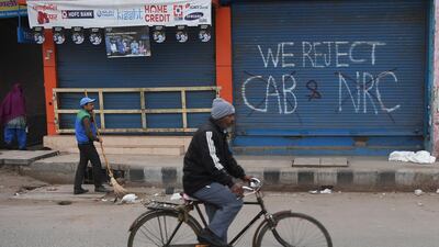 A man cycles past graffiti against India's Citizenship Amendment Act in New Delhi. AFP