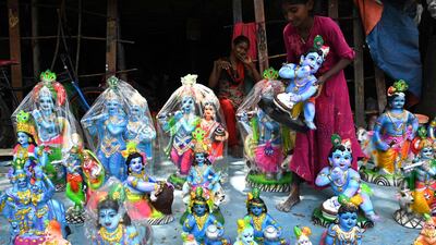 Idols of Krishna being sold ahead of the festival. AFP