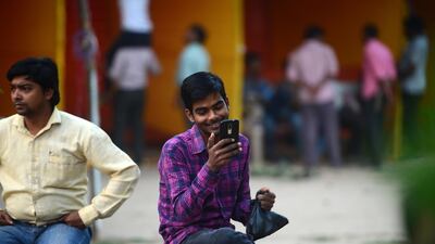 An Indian man uses a smartphone for a video call at a park in Allahabad. AFP