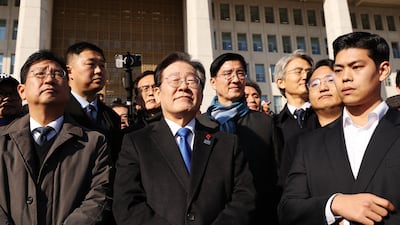 Lee Jae-Myung, centre, leader of the opposition Democratic Party, stands in front of the National Assembly. EPA