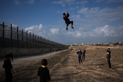 Palestinians displaced by the Israeli bombardment of northern Gaza play on the Salah Al Din strip, in Rafah, on the border with Egypt. AP