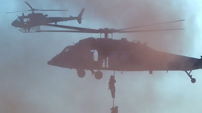 Paratroopers landed to tackle threats, behind mountain blocks depicting Jebel Hafeet