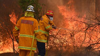 Firefighters tackle a bushfire to save a home in Taree, 350km north of Sydney as they try to contain dozens of out-of-control blazes that are raging in the state of New South Wales. AFP