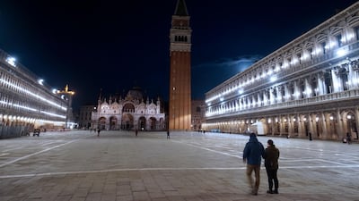 People walk in an almost empty St. Mark's Square in Venice, Italy. AP