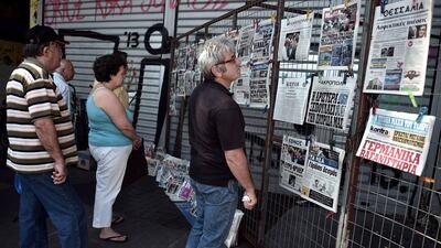 Greeks reading newspaper headlines in central Athens on July 13, 2015 as Greece reached a desperately-needed bailout deal with the eurozone after marathon talks overnight. Aris Messinis/AFP Photo