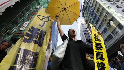 A pro-democracy protester chants at an occupied area before the barricade is removed in Mong Kok district of Hong Kong. Hong Kong authorities on Tuesday began clearing away some barricades from part of the pro-democracy protest site, scene of previous violent confrontations with police and angry mobs. The yellow banners read: “I want genuine universal suffrage.” Kin Cheung / AP