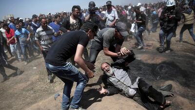 An elderly Palestinian man falls on the ground after being shot by Israeli troops during a deadly protest at the Gaza Strip's border with Israel, east of Khan Younis, Gaza Strip on May 14, 2018. (AP Photo/Khalil Hamra, File)