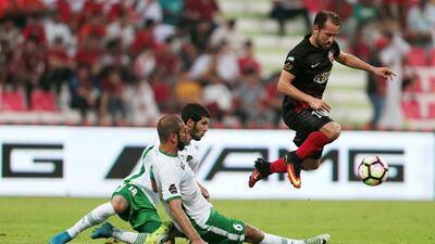 Al Ahli’s Everton Ribeiro, right, controls the ball while jumping over Emirates’ Alhassan Saleh, bottom left, and Hadef Saif, bottom right. Christopher Pike / The National