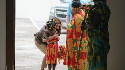 After receiving flowers, Melania Trump embraces the flower girl as she arrives at the Emintsimadze Palace in Cape Coast, Ghana. AP Photo
