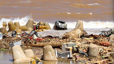 A destroyed vehicle lies on the seashore as waves break in Derna on September 19, last year.