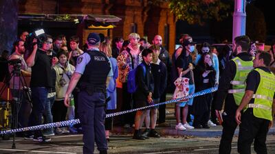 Pedestrians stand behind a police cordon. AFP