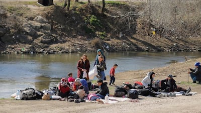 Turkish people give clothes to migrants, next to the Tunca river in Edirne, Turkey. Reuters