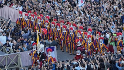 Swiss Guards march as the white smoke billows. AP